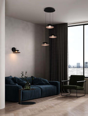 Morfi Wandleuchte 3000K Schwarz, Gold an der Wand in modernem Wohnzimmer mit Sofa und Pendelleuchten