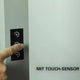 Benutzer betätigt den Touch-Sensor eines LED-Bürolampe mit Bewegungsmelder und Tageslichtsensor.