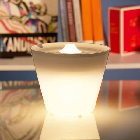 Rotaliana Multipot+ table lamp cable container + charging station White on a table, lighting in a modern design.