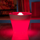Rotaliana Multipot+ table lamp cable container + charging station white glowing red on a table.