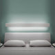 Nemo Angolo LED Eckleuchte 200cm installiert über einem modernen Bett mit grauem Kopfteil.
