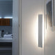 Nemo Angolo Mezzo LED Ecklampe 100cm an einer Wand installiert, indirektes Licht in einem modernen Raum.