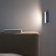 Nemo Applique Cylindrique Petite Wandlampe 16cm an einer Wand neben einem Bett mit einem Buch.