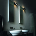 Nemo Ara 29 LED Wandleuchte in modernem Badezimmer mit zwei Spiegeln und Waschbecken.