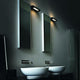 Nemo Ara 29 LED Wandleuchte in modernem Badezimmer mit zwei Spiegeln und Waschbecken.