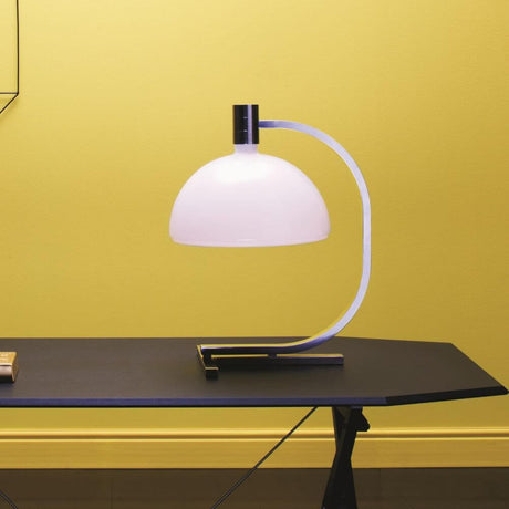 Nemo As1C Tischlampe Albini mit Glasschirm auf einem schwarzen Tisch vor gelber Wand.