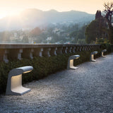 Borne Béton Grande Outdoor Beleuchtung entlang einer Gartenpromenade bei Sonnenuntergang.
