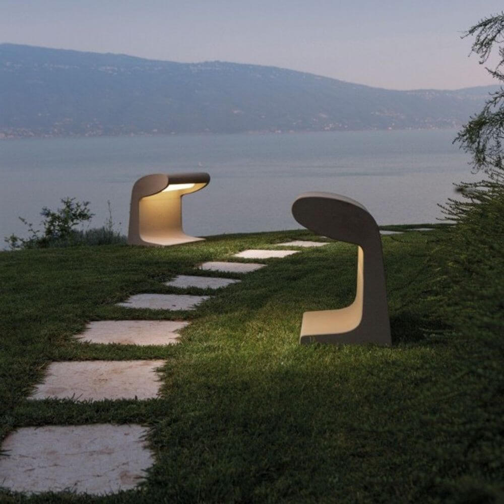 Nemo Borne Béton Grande LED Stehlampe IP44 auf Wiese am See, handgefertigt aus Zement, einzigartiges Design.