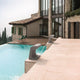 Nemo Borne Béton Petite Outdoor LED Tischlampe IP44 am Pool mit modernem Haus im Hintergrund.