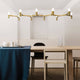 Nemo Crown Plana Esstischlampe, 10-flg. aus Messing, diffuses Licht über eleganter Tischdekoration.