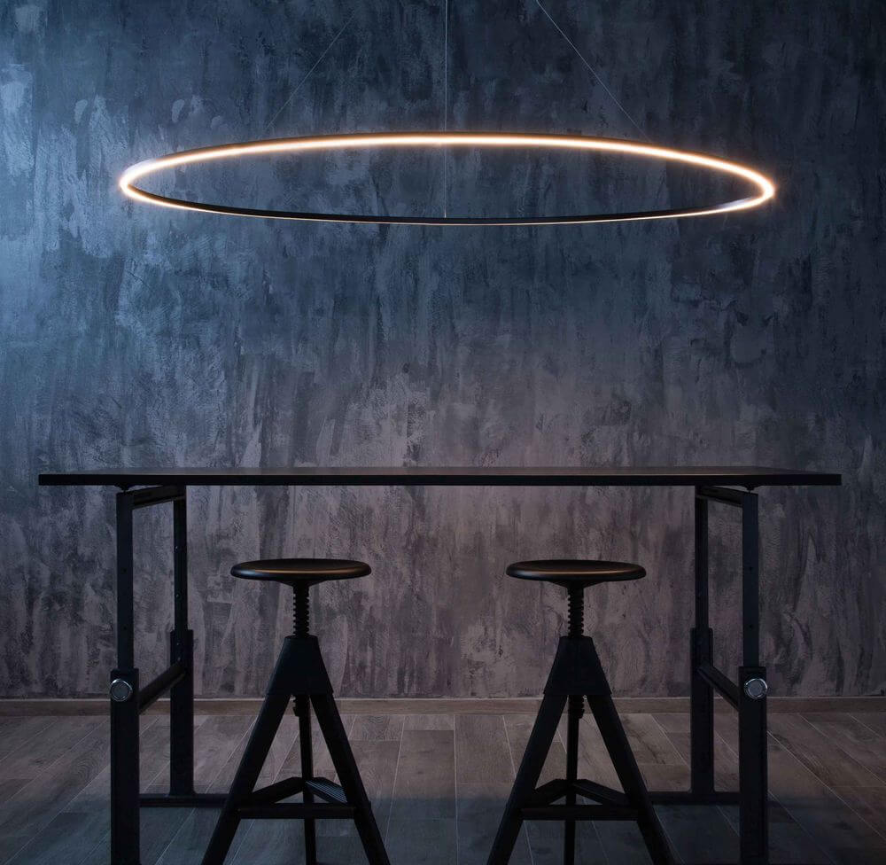 Nemo Ellisse Mega Down LED Hängelampe 186x95cm direkt über einem modernen Tisch mit Hockern.