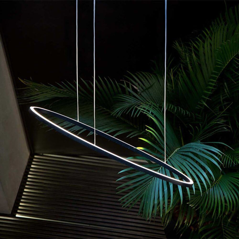 Moderne ovale LED-Pendelleuchte mit indirektem Licht, umgeben von Pflanzen im eleganten Interieur.
