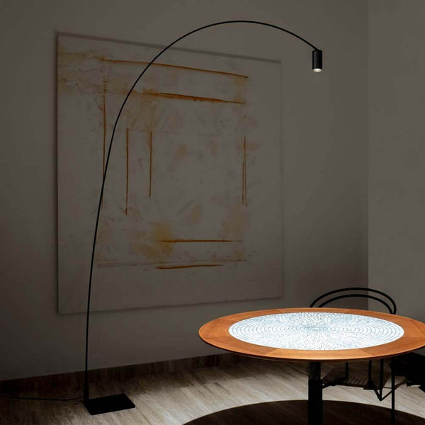 Nemo Fox LED Stehlampe Leselampe in einem stilvollen Raum über einem Holztisch.