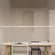 Nemo Linescapes Horizontal 200 LED Hängeleuchte drehbar über einem modernen Tisch in einem minimalistischen Raum.