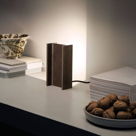 Nemo Mais Plus Que Cela Je Ne Peux Pas Mini LED-bordlampe på et bord med bøker og en skål med nøtter.