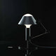 Nemo Mr. Light Tischlampe mit beweglichem Arm und mattschwarz lackierter Metallstruktur auf schwarzem Hintergrund.