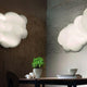 Nemo Nuvola Minor LED Wand- & Deckenleuchte Wolke 100cm an einer Wand installiert, weiches Licht auf einem Tisch.