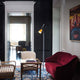 Moderne Stehlampe in stilvollem Wohnzimmer mit rotem Sessel und Kunstwerk an der Wand.