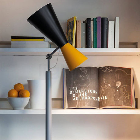 Lampadaire Nemo Parliament indirect/direct avec diffuseur noir et jaune, bibliothèque et décoration avec des oranges.