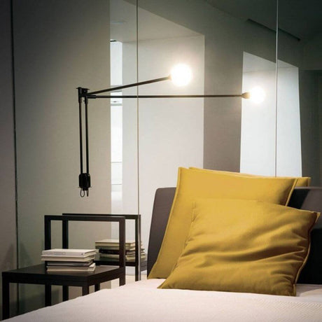 Nemo Potence Pivotante Mini Wandlampe 100cm an einer Wand montiert, mit mattschwarzer Oberfläche und schwenkbarem Arm.
