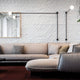 Nemo Potence Pivotante Wandlampe 200cm an einer Wand über einem modernen Sofa in einem stilvollen Wohnzimmer