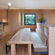 Nemo Potence Pivotante Wandlampe 200cm in modernem Innenraum mit Holzdetails und Pflanzen.