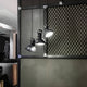 Nemo Projecteur 165 Hängeleuchte verstellbar in modernem Interieur mit schwarzem Netzpaneel.