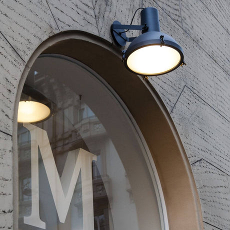 Nemo Projecteur 365 Outdoor Wandstrahler IP65 an einer Wand montiert mit beleuchtetem Fenster im Hintergrund.