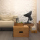 Nemo Projecteur 365 Stehlampe neben einer gemütlichen Couch und Holzkisten in modernem Raumdesign.