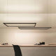 Nemo Spigolo Horizontal LED Hängeleuchte drehbar über einem modernen Schreibtisch mit klarer Beleuchtung.