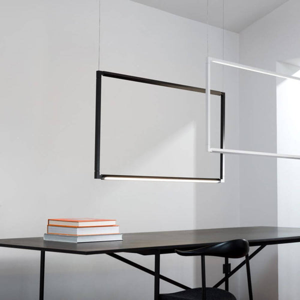 Nemo Spigolo Lodret LED Hængelampe 114x58cm i et moderne rum med bord og stakke af bøger.