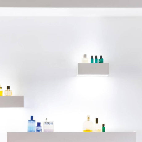 Nemo Viiva 30 LED Wandlampe Regal beleuchtet Regale mit Pflegeprodukten auf weißer Wand.