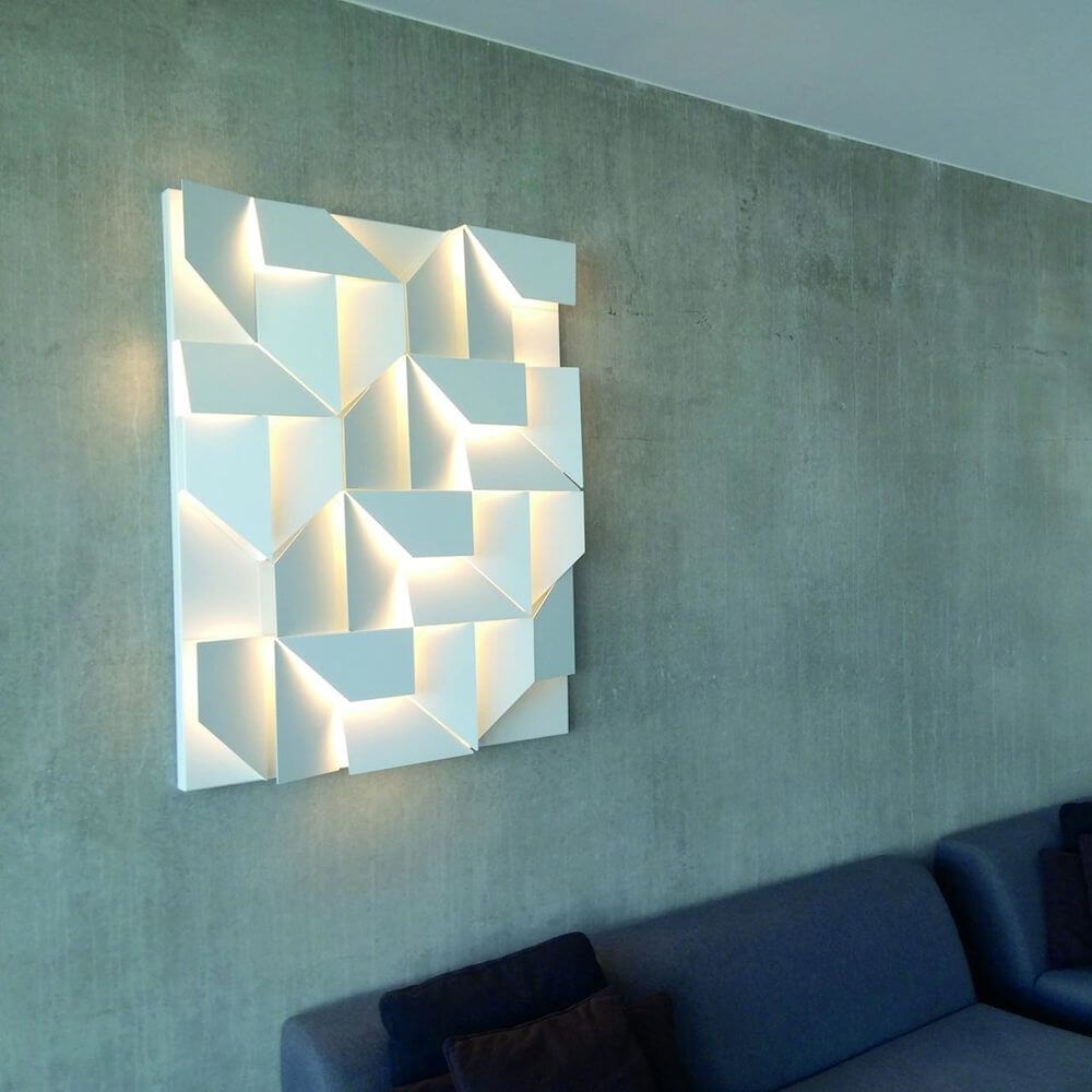 Nemo Wall Shadows Grand LED Wandlampe 120x90cm an einer betonartigen Wand über einem Sofa.