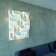 Nemo Wall Shadows Grand LED Wandlampe 120x90cm an einer betonartigen Wand über einem Sofa.