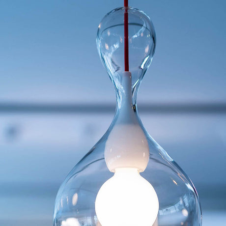 Blubb Glas-Pendellampe Mundgeblasen mit mundgeblasenem Glas und weißer Lampenfassung, aufgehängt an rotem Kabel.