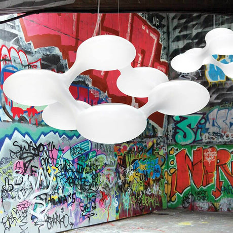 Moderne Cosmo LED Pendellampe Ø 160cm in Weiß hängt vor bunter Graffiti-Wand.