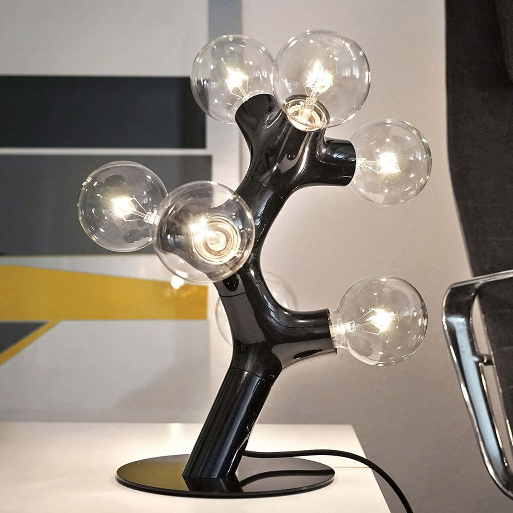 DNA Triple Tischleuchte 7-flg. mit organischem Design und 7 Glaskugeln auf einem modernen Tisch.