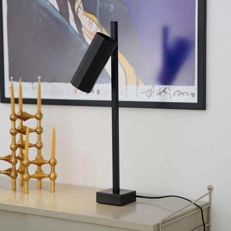 Lampe de table Alanis avec un profil à 10 côtés sur un buffet, design élégant en noir.