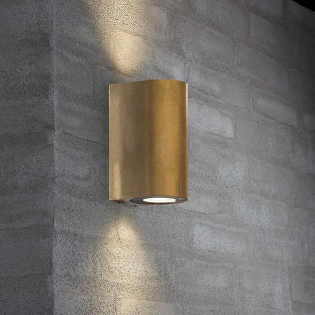 Utendørs vegglampe Canto Maxi 2 IP44 messing på en betongvegg, minimalistisk og stilfull.