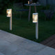 Coupar Pollerleuchte IP54 im Garten mit sanftem Licht und modernem Design, ideal für stimmungsvolle Beleuchtung.