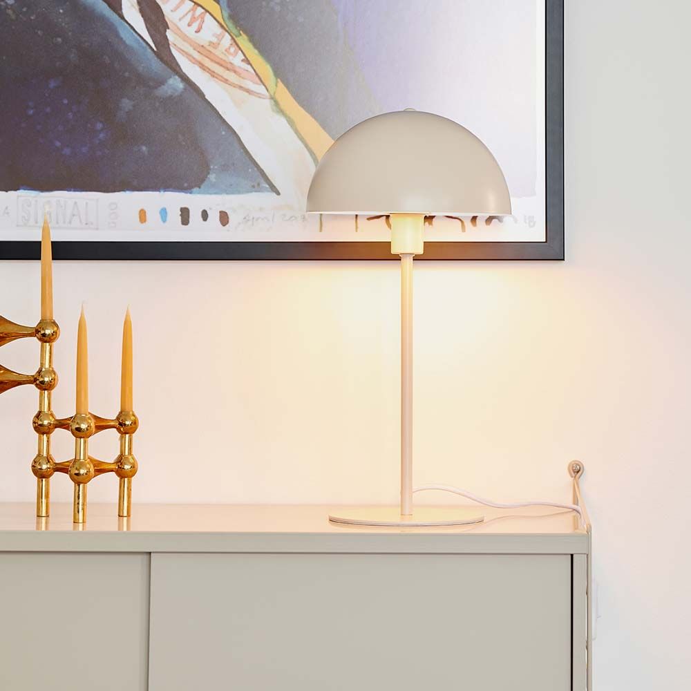 Ellen Tischleuchte Beige mit modernem skandinavischen Design auf einem Sideboard, schafft sanftes Licht.