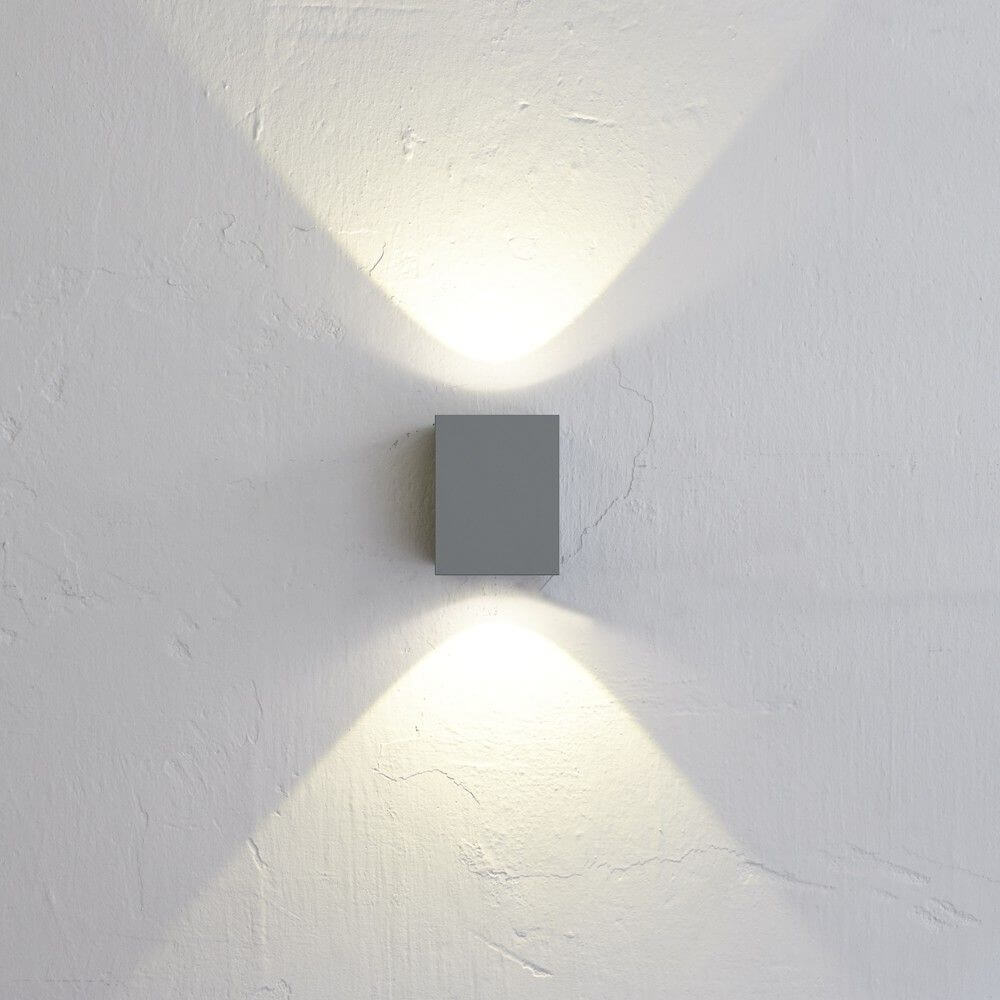 LED Außen-Wandlampe Canto Kubi 2 IP44 Grau an einer Wand, strahlend mit Licht nach oben und unten.
