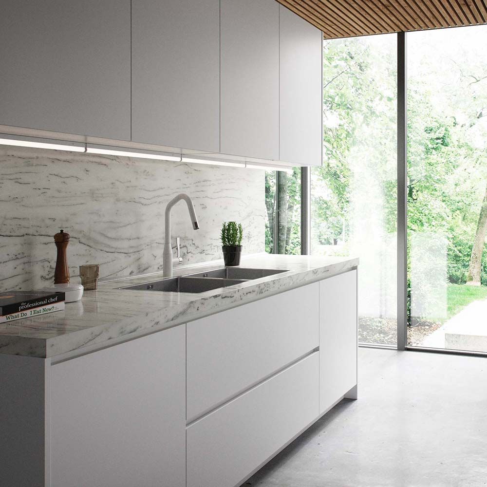 Moderne Küche mit weißen Möbeln, Marmortheke und LED Lichtleiste unter den Oberschränken.