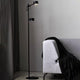 LED Stehleuchte Clyde 2-flammig Schwarz in modernem Wohnambiente neben Sofa mit Decke.