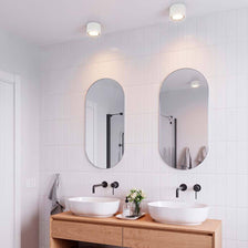 Landon LED bathroom ceiling light IP44 in a modern bathroom with mirrors and washbasins.