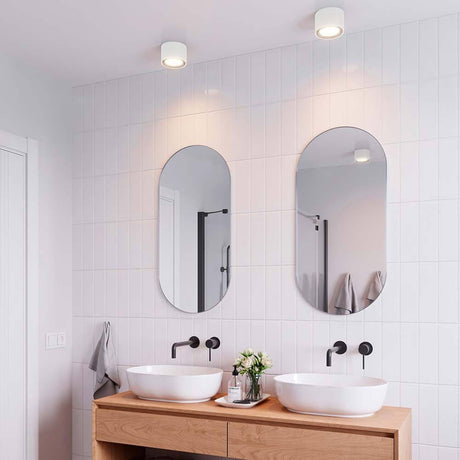 Landon LED Bad Deckenleuchte IP44 in modernem Badezimmer mit Spiegeln und Waschbecken.