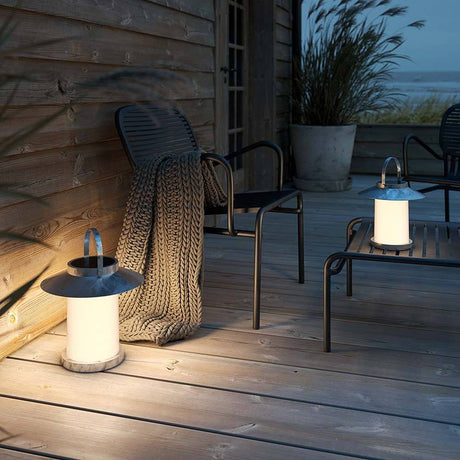 Temple LED lampadaire solaire de sol IP54 sur une terrasse avec des chaises et une couverture.