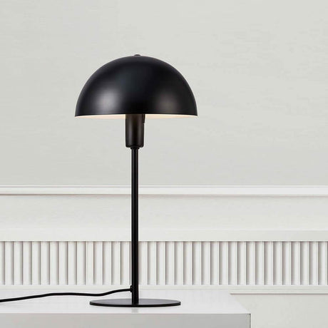 Lampe de table Ellen Noir sur une table, design minimaliste avec abat-jour rond et cadre élégant.