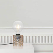 Table lamp Hollywood amber on a table with a glass globe and decorative base.