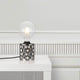 Tischleuchte Hollywood Rauch auf einem Tisch in einem modernen Raum, mit runder Glühlampe.